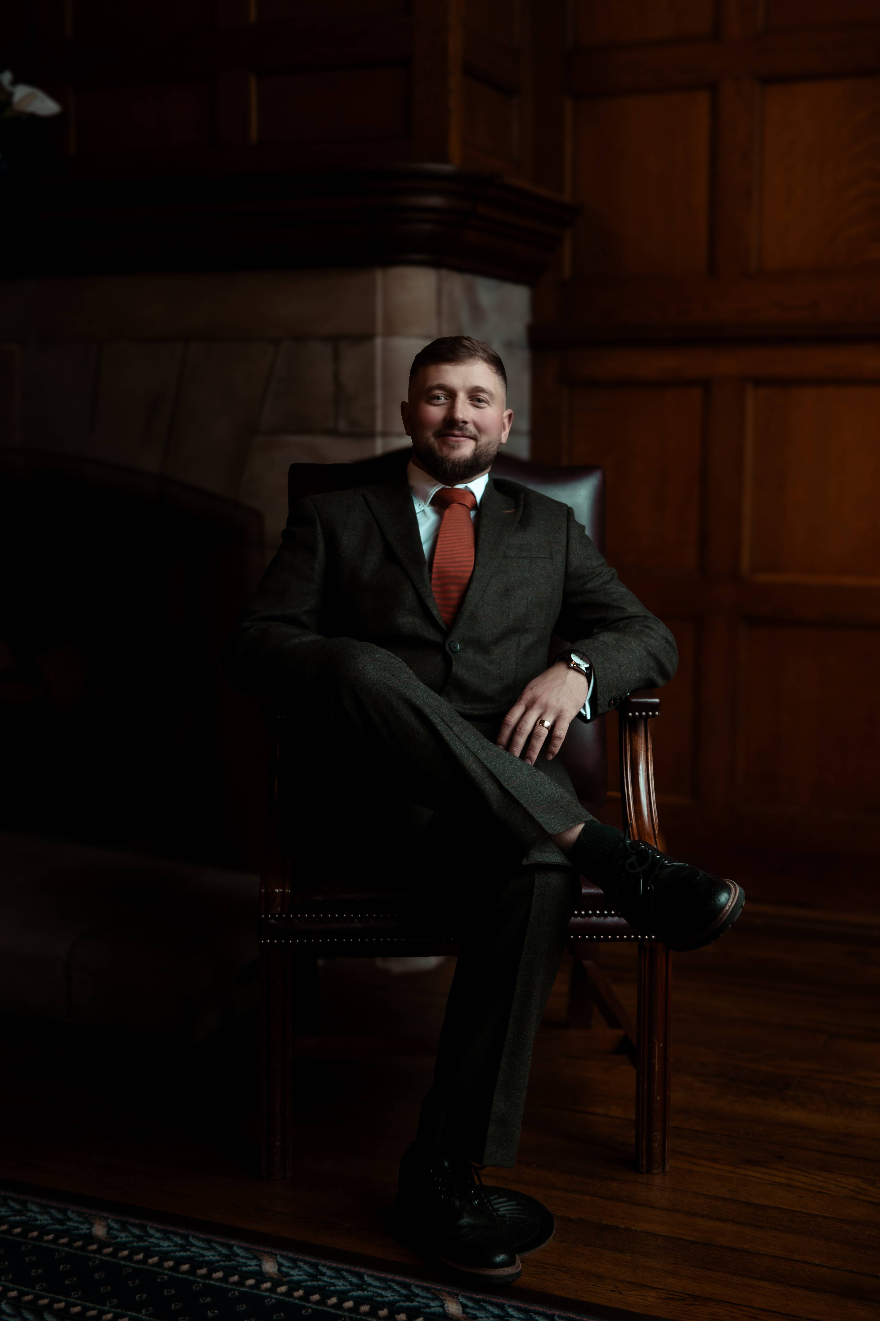 Groom seated in an elegant, moody portrait