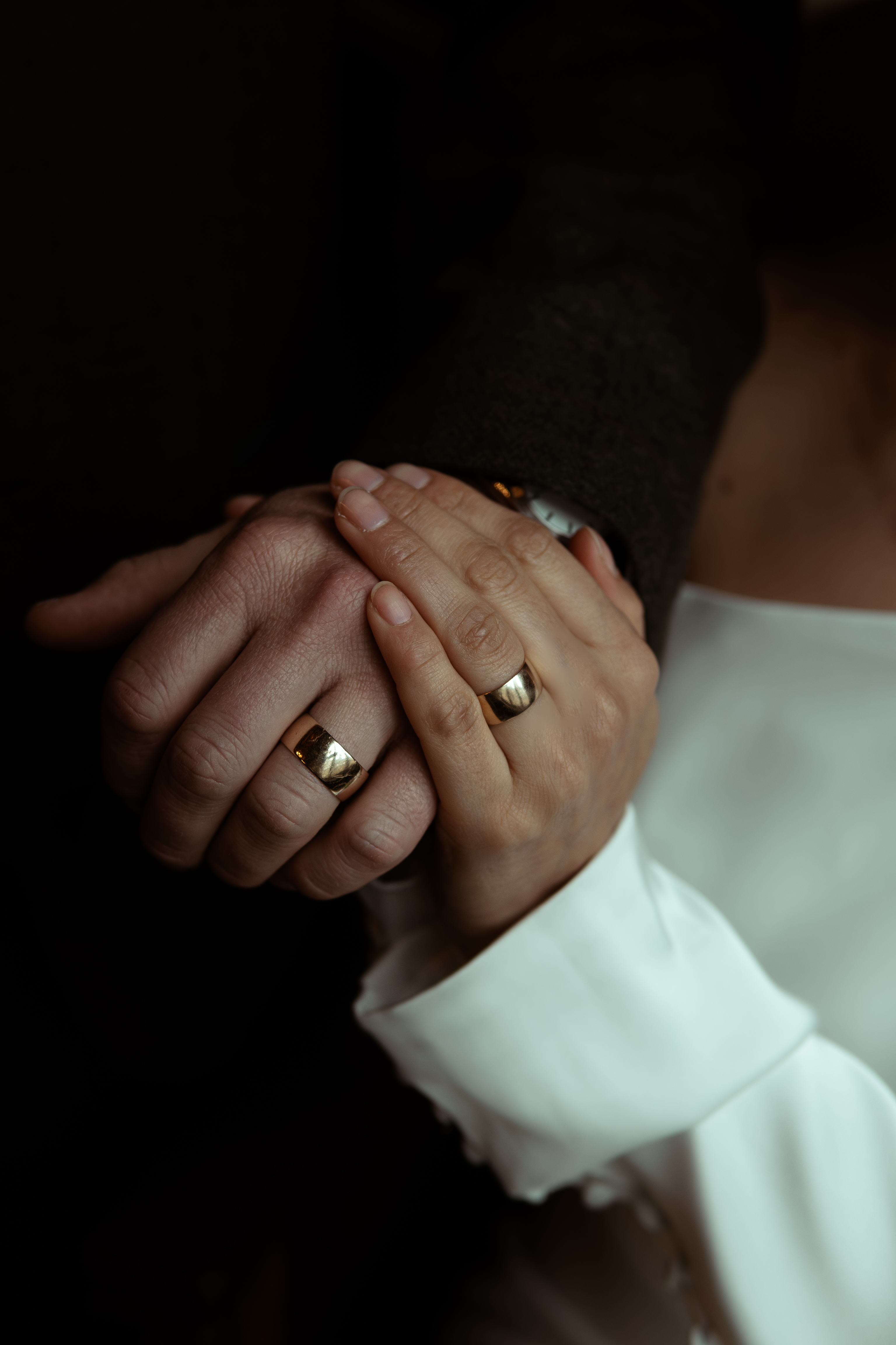 Close-up of a couple's hands and wedding ring